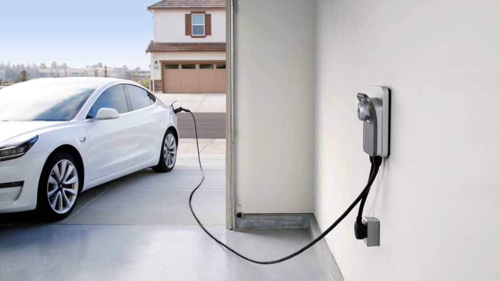 Electric Vehicle Car in the driveway being charged by a level 2 EV Charger.