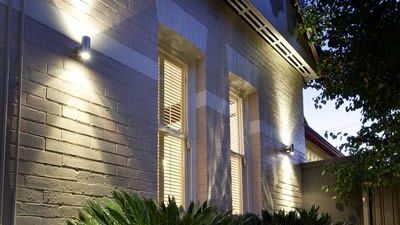 Residential house with outdoor wall lighting installed that is also synced up to motion sensors.