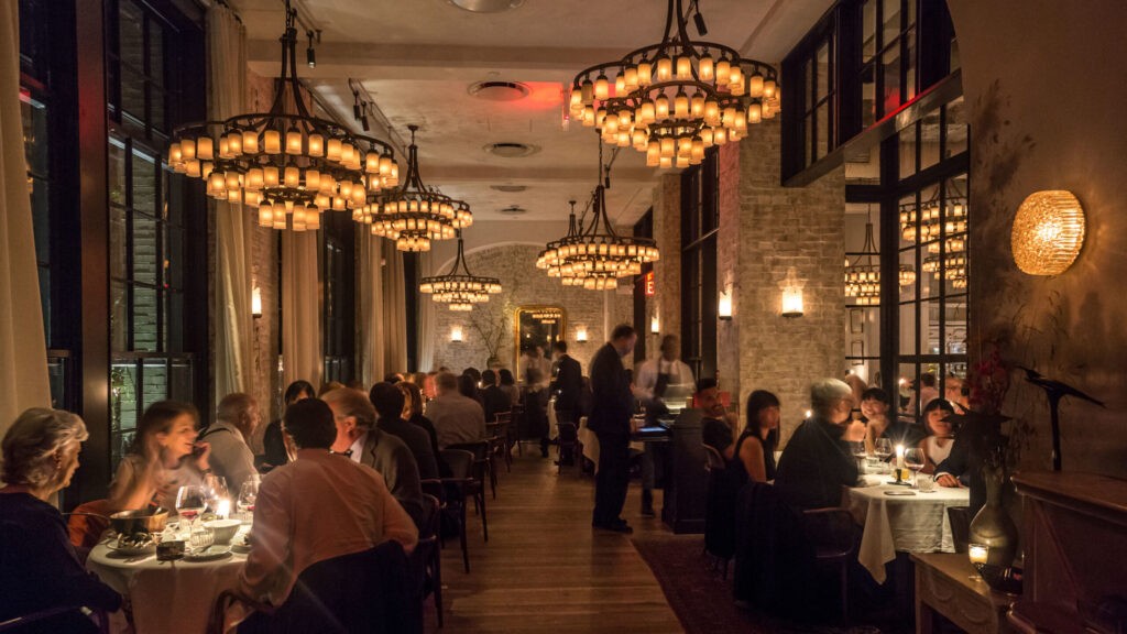 Dinner time at a busy restaurant with a low light temperature that helps set the mood.