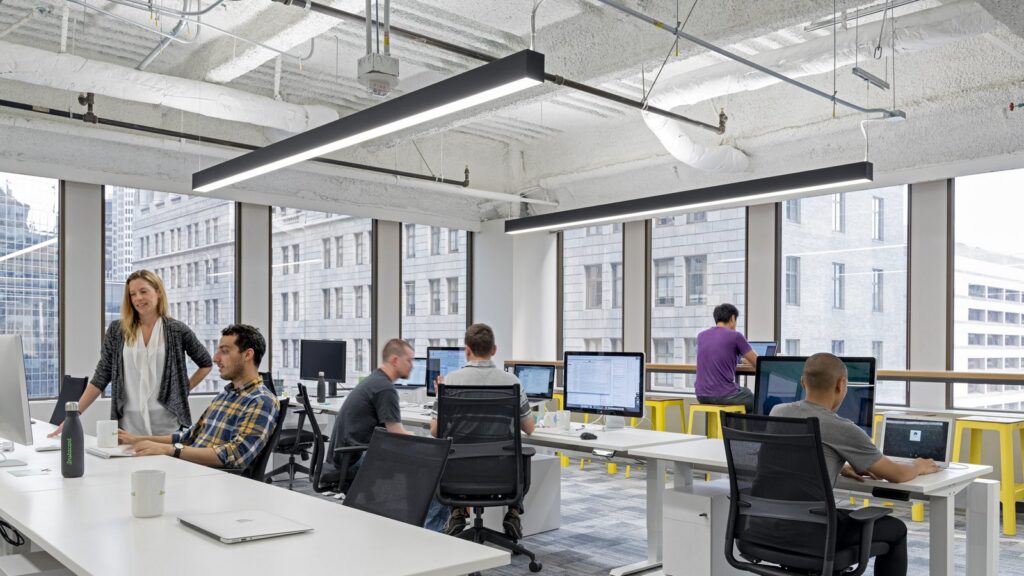 Office with hanging light fixtures installed by a team of commercial electricians.