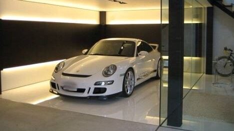 Garage with a sports car that has linear lights running along the wall.