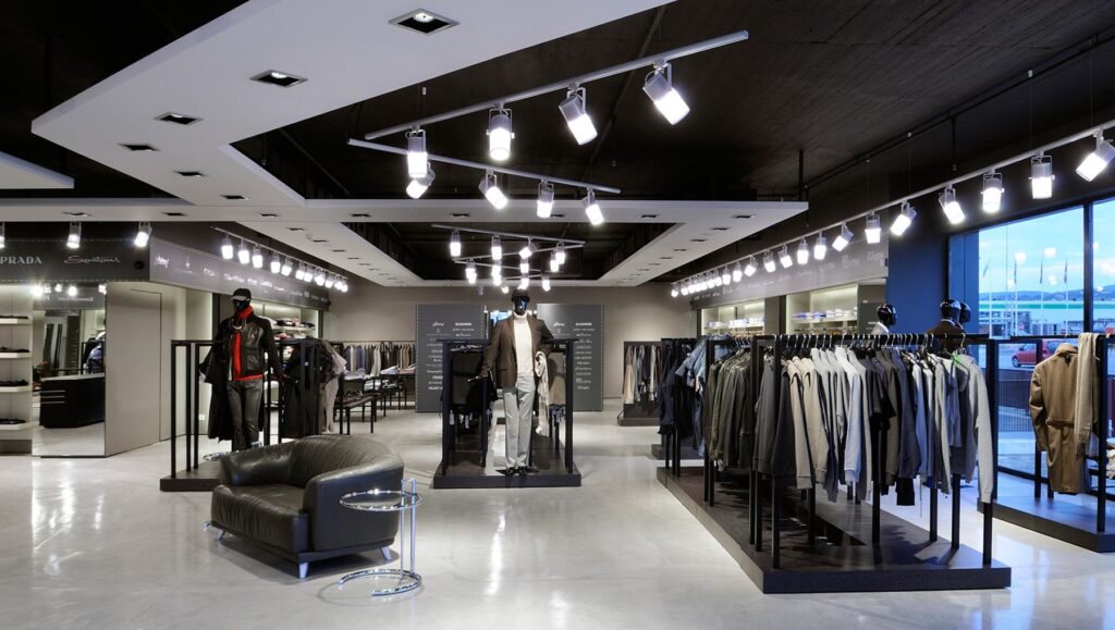 Retail store with track lighting installed in the ceiling in a V shape. 