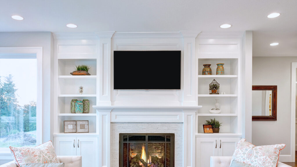 Living room with pot lights installed on the opposite sides of the television.