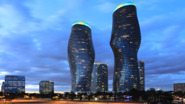 The marilyn monroe towers in Mississauga Ontario, at night, with ambient lighting from the sun setting.