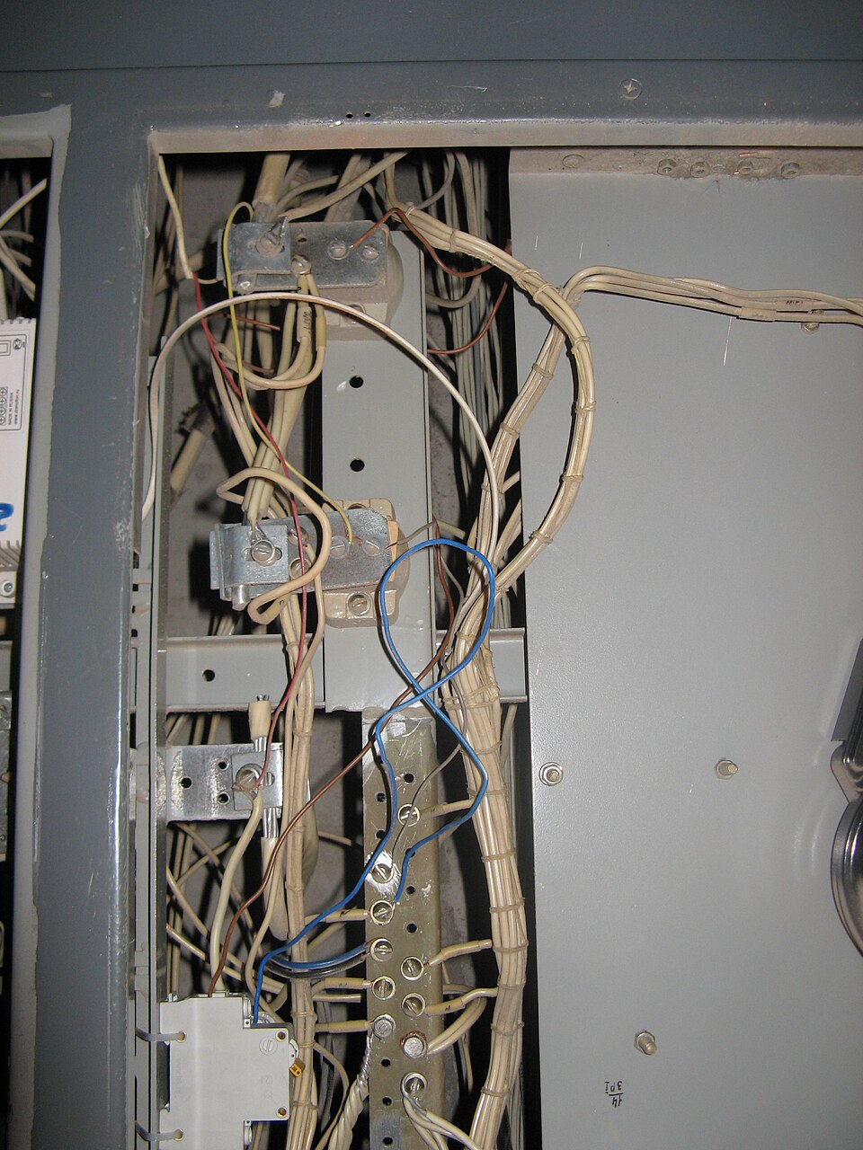 Tangled, badly dressed wiring crammed into an old electrical panel