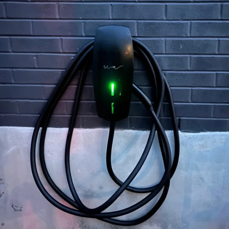 EV charger installation by 3e Electrical — black Tesla Wall Connector on a dark brick wall