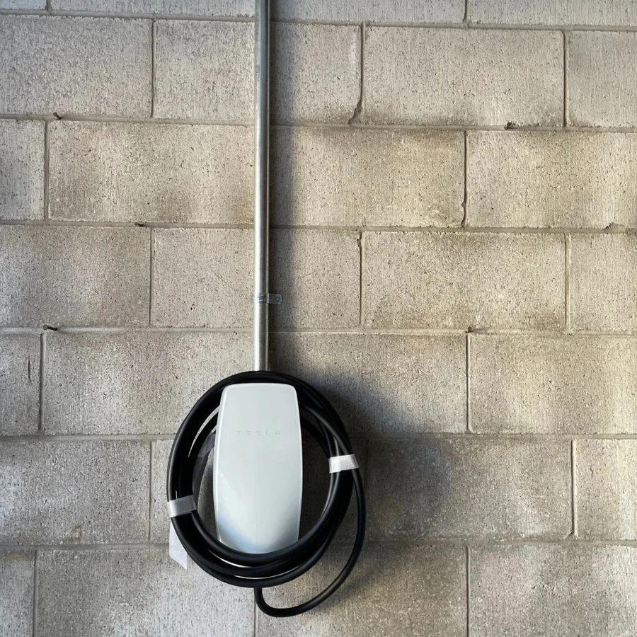 EV charger installation by 3e Electrical — white Tesla Wall Connector on a concrete block wall