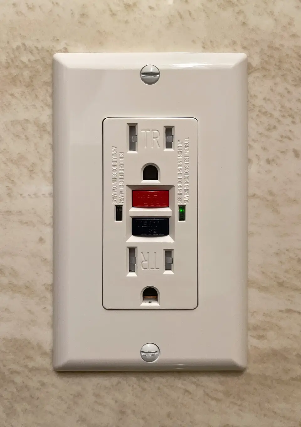 A new GFCI receptacle installed by 3e Electrical, straight and clean on a tiled wall
