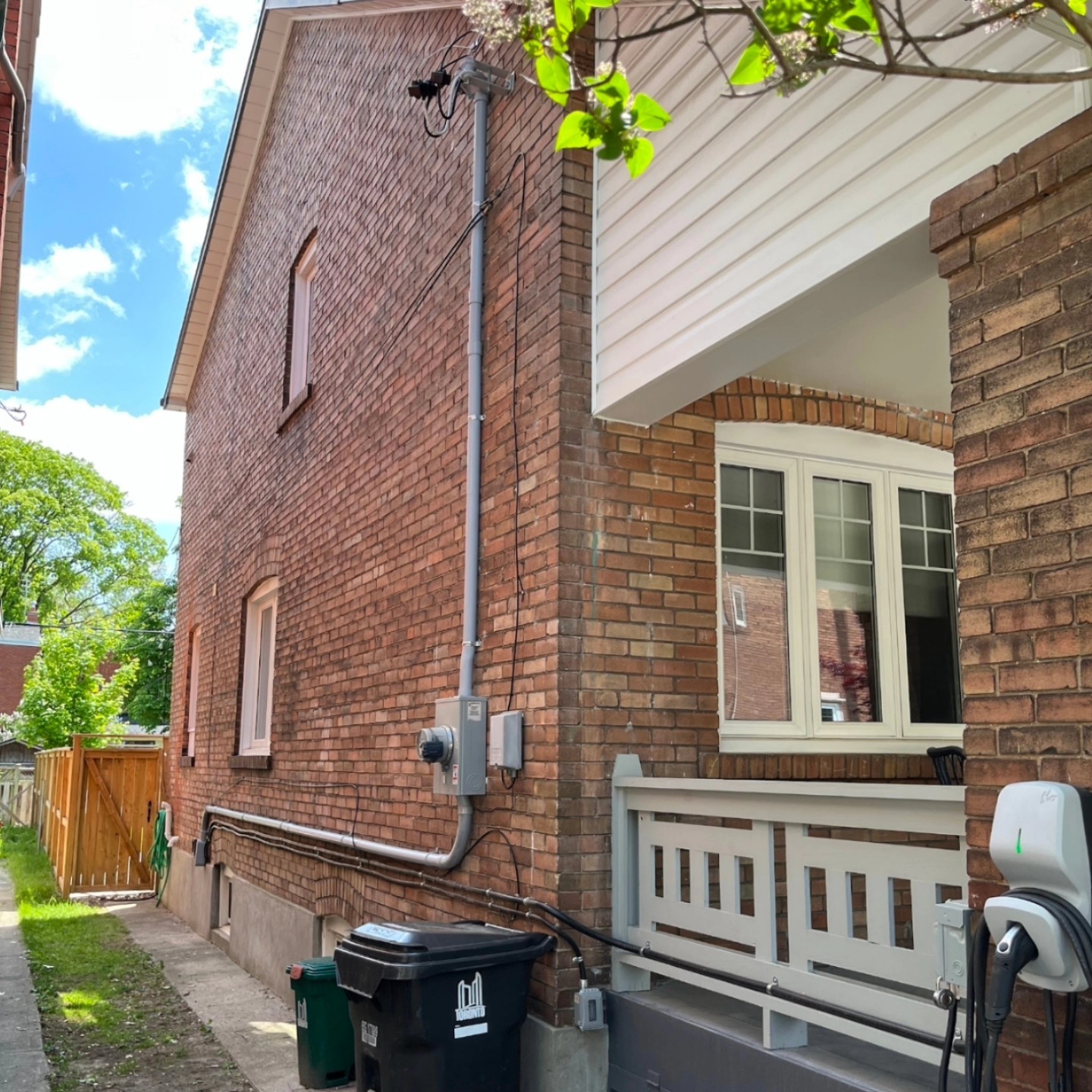 EV charger and service mast installed by 3e Electrical on a Toronto brick home