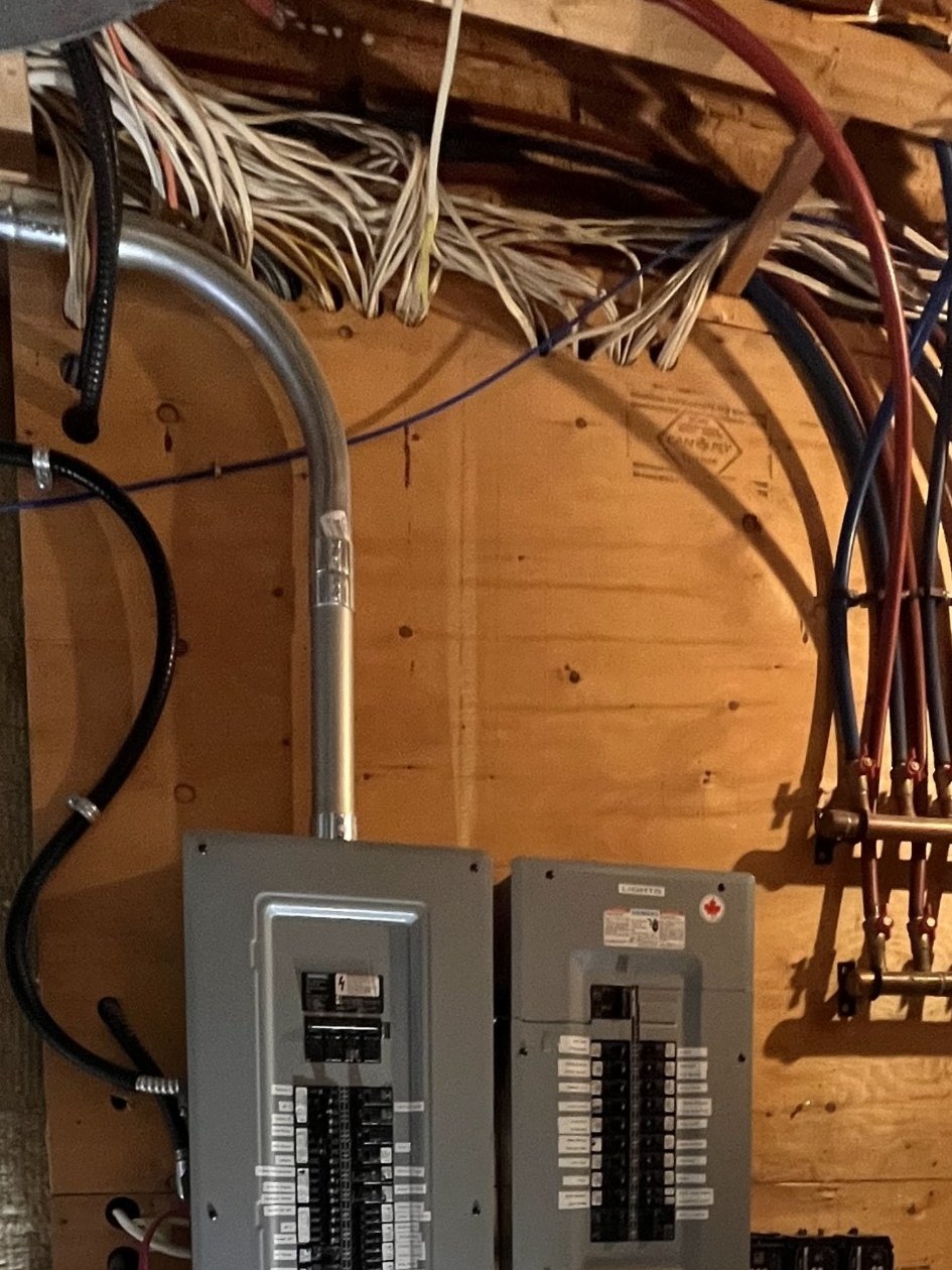 Example photo: the ceiling and cable runs directly above an electrical panel