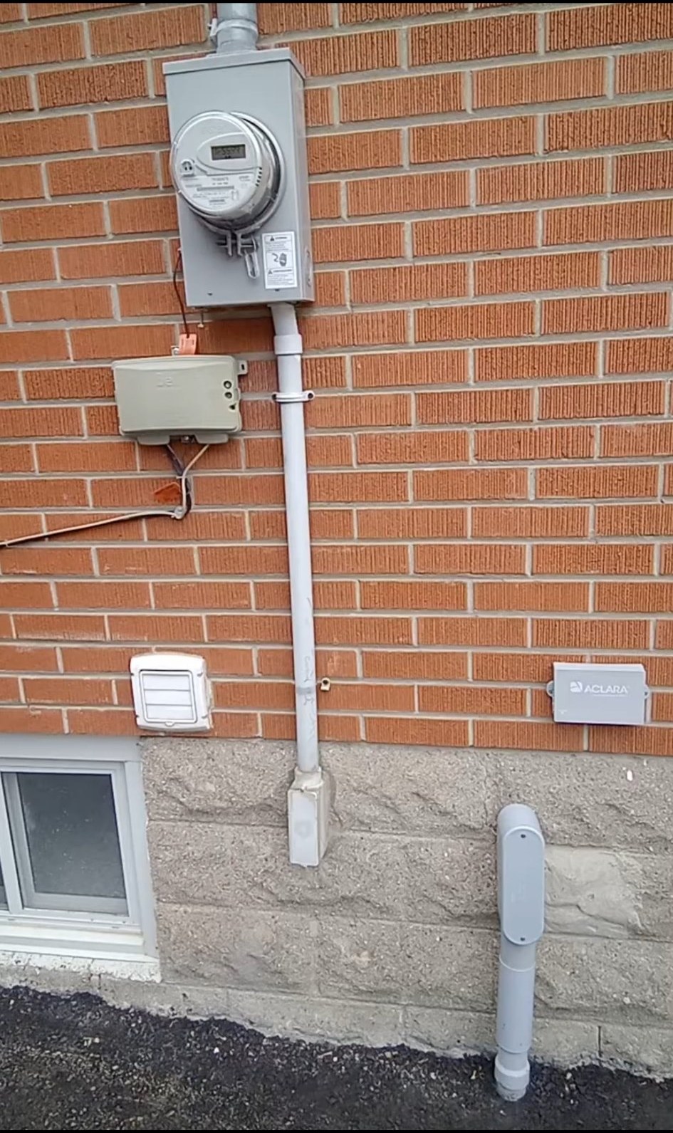 Example photo: a home’s service entrance — the meter, the conduit running down from it, and where it enters the house, all in one wide shot